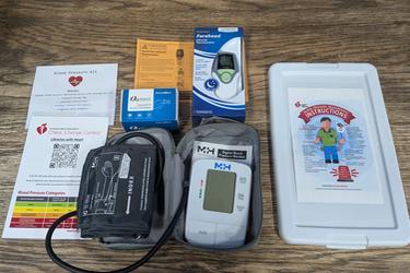 Show the contents of the Talking Blood Pressure Self-monitoring kit. Our other Blood Pressure kit is similar, though this one includes a larger cuff, audio cable, and extra instructions for the talking portion.